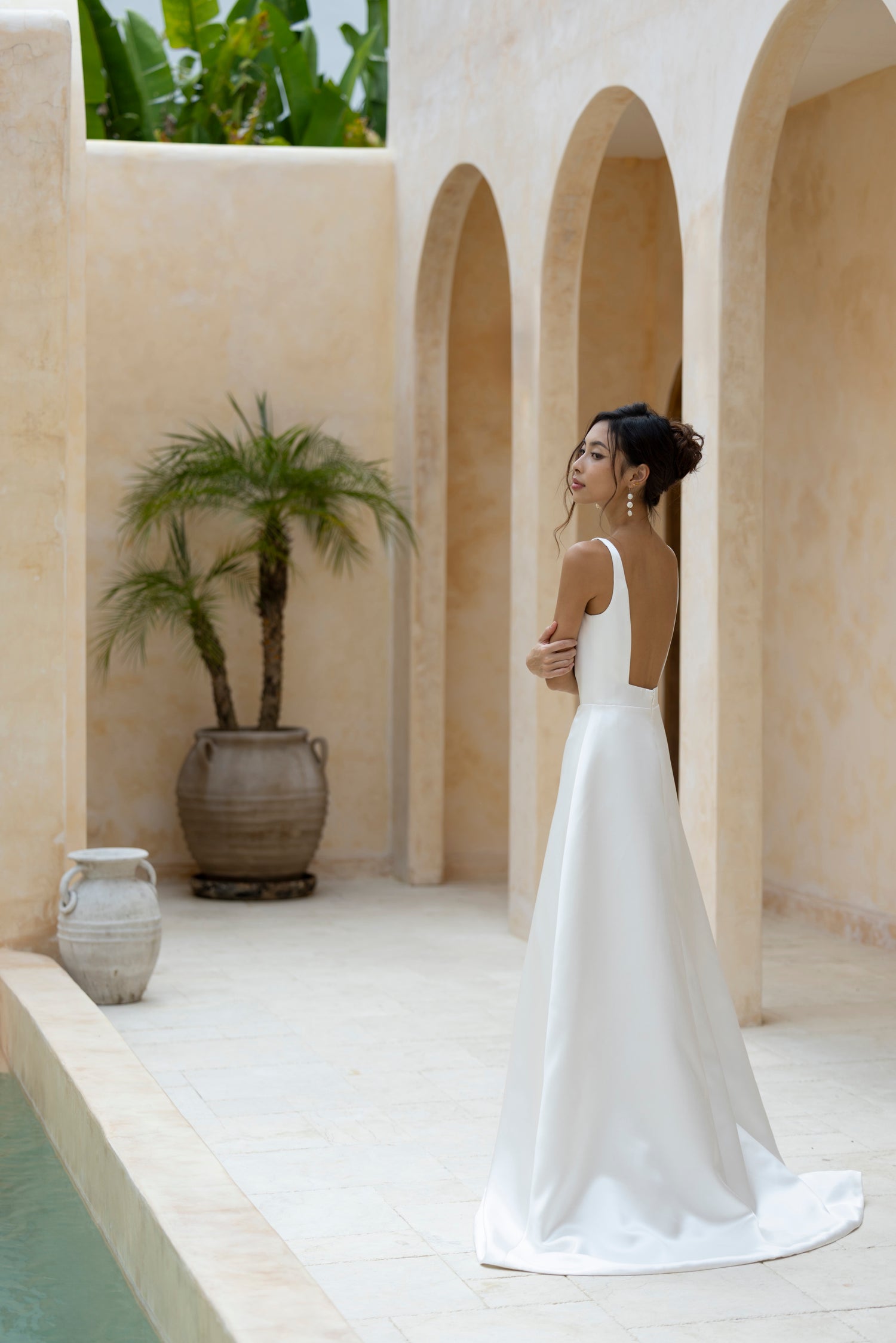 Bride in Capri wedding dress with low back and A-line satin skirt by TheWolfandLily