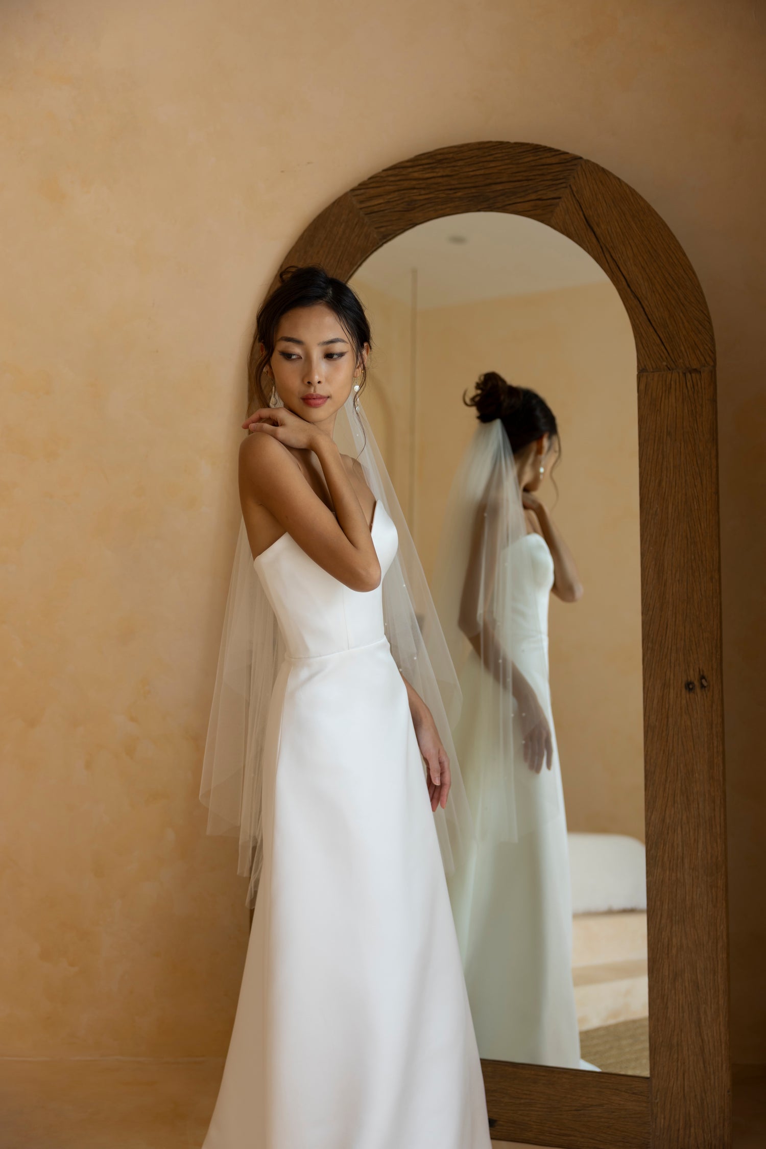 Bride wearing Hally satin strapless wedding gown with sweetheart neckline and soft A-line skirt – front view by TheWolfandLily