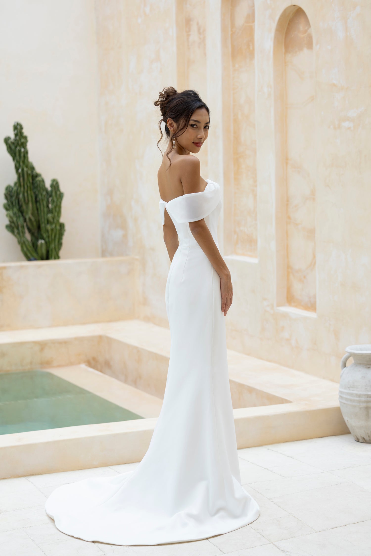 Bride showing the back view of the Robin gown by TheWolfandLily, short train and fitted silhouette