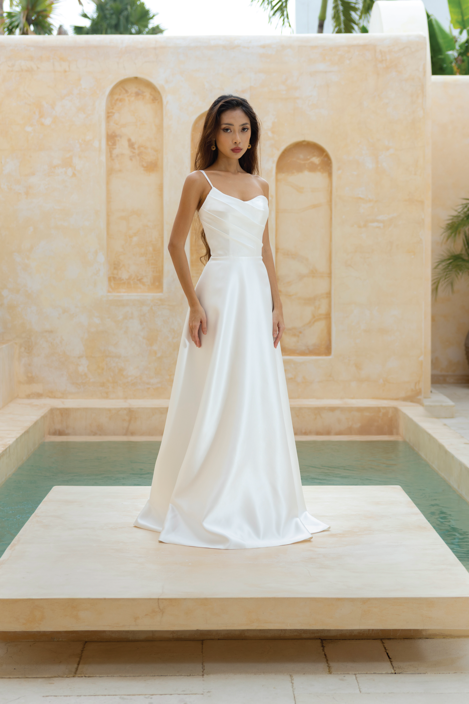Bride in the Sloane A-line wedding dress with pleated bodice and toga neckline by The Wolf and Lily