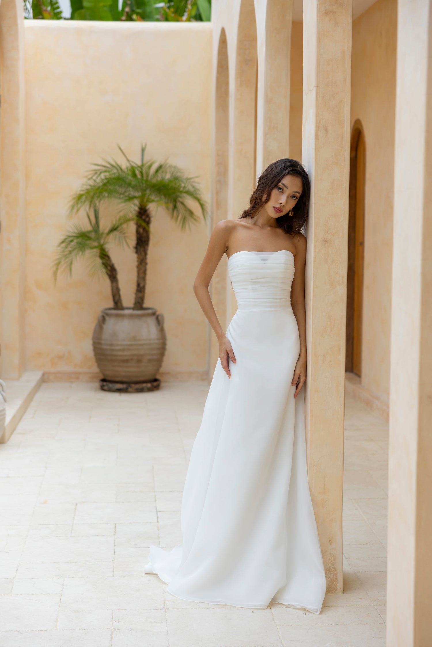 Bride in the Charlie strapless wedding gown by The Wolf and The Lily, featuring ruched bodice and soft A-line skirt, perfect for minimalist bridal looks.