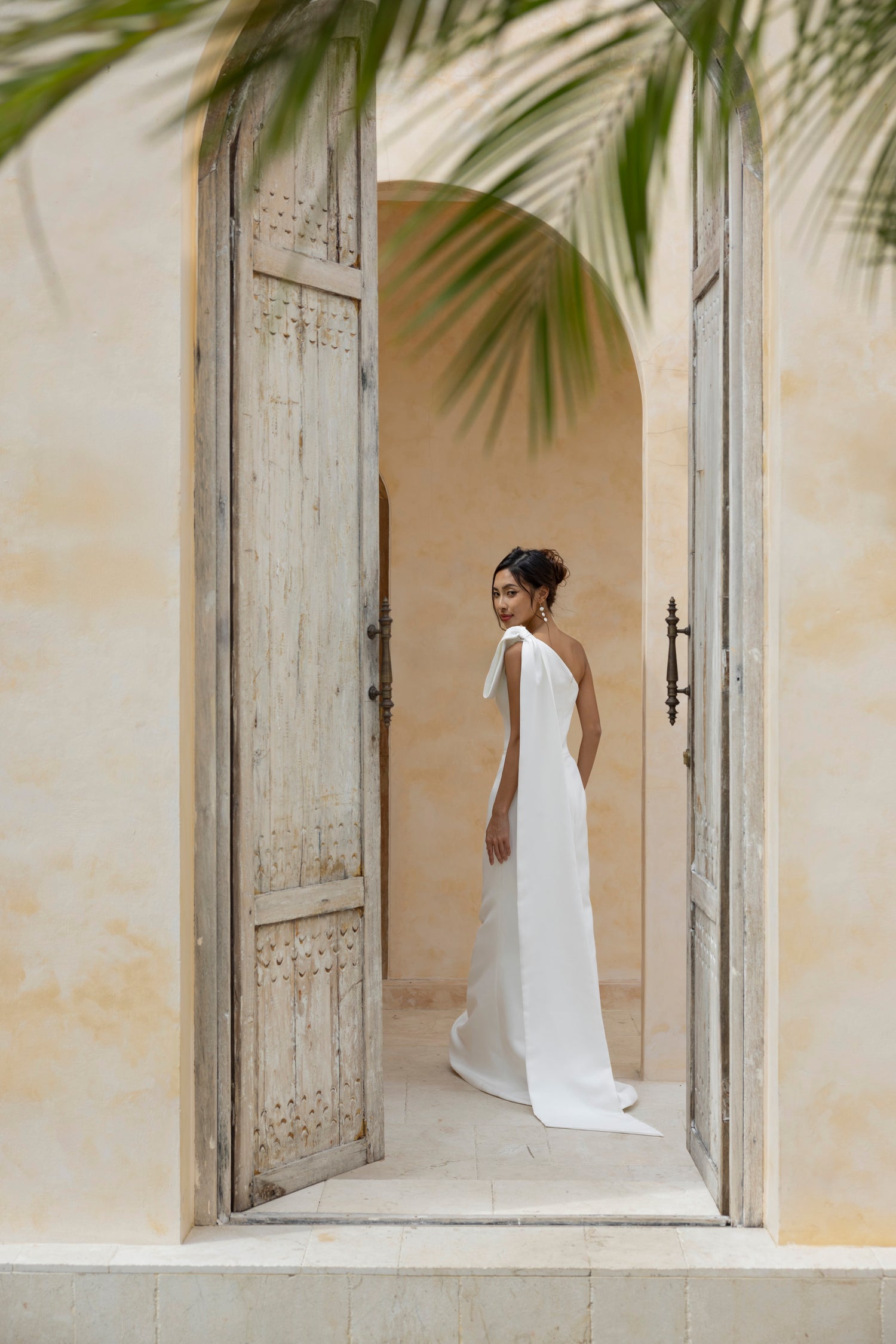 Modern one-shoulder wedding dress with detachable bow, perfect for brides who love clean lines and effortless drama.